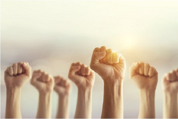 Peoples raised fist air fighting and sunlight effect, Competition, teamwork concept.