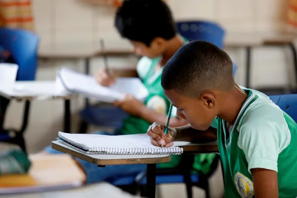menino-escrevendo-em-caderno-em-texto-sobre-educacao-no-brasil