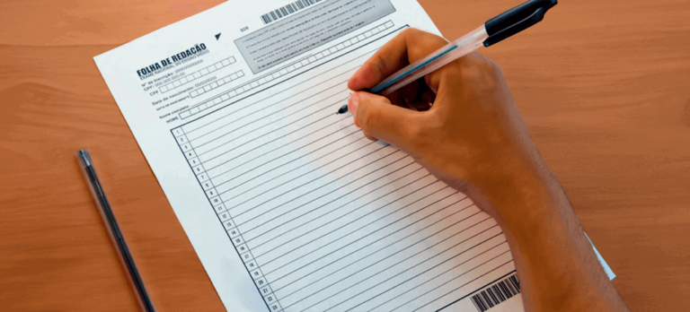 30708b1b-mao-segurando-caneta-preta-escrevendo-introducao-redacao-enem